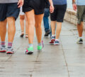 Several-People-Walk-Down-Sidewalk-Doing-Exercise